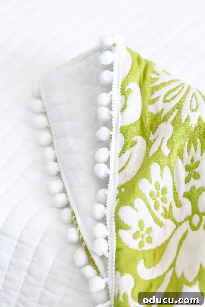DIY Fabric Throw Blanket: So Easy, So Pretty 3 close up of pom-pom trim detail on a DIY throw blanket.