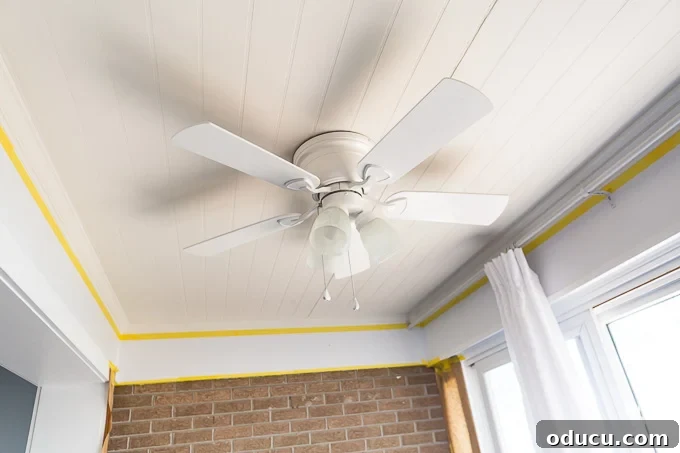 White ceiling fan hanging from white bead board ceiling