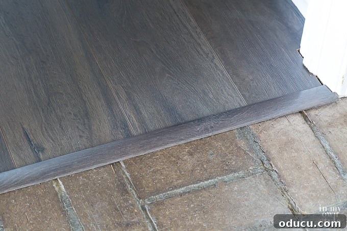 Select Surfaces Floor molding transition strip between two different rooms. Floor molding transition strip between two different rooms, demonstrating a smooth connection.