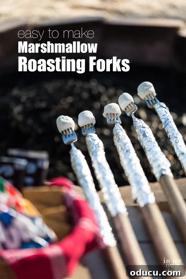 DIY Marshmallow Roasting Forks: The Best Campfire Cooking Sticks for S'mores and Outdoor Fun Five beautifully crafted DIY marshmallow roasting forks, made with metal forks attached to long poles, are artfully positioned over a glowing outdoor fire pit, ready for a fun session of campfire cooking and s'mores making. Perfect for family picnics, scout camping trips, church retreats, and backyard entertaining.