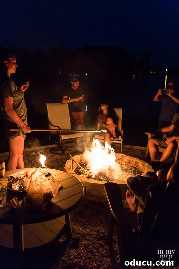Backyard Entertaining Made Easy: DIY Marshmallow Roasting Forks for S'mores Around the Fire Pit A happy family gathered around a cozy backyard fire pit, enjoying the simple pleasure of roasting marshmallows with their homemade DIY roasting forks. This picture captures a perfect evening of outdoor entertainment and family bonding.