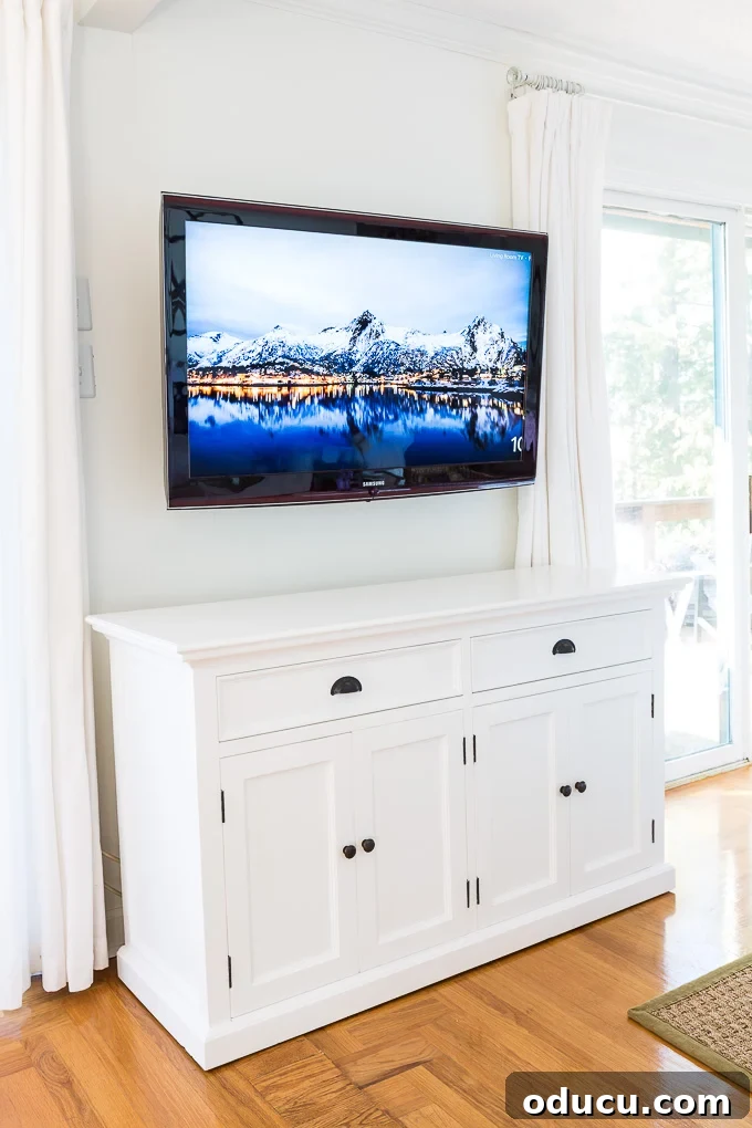 Illuminate Your Space: Easy Hacks for a Brighter Room 2 Modern buffet with four doors positioned under a wall-mounted television, contributing to a bright living room decor.