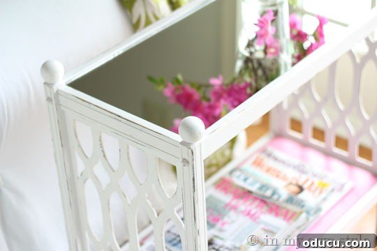 Where should I place a mirror in a dark room? A mirror-topped table reflecting light, a clever decorative detail to enhance brightness in a room through reflective surfaces.