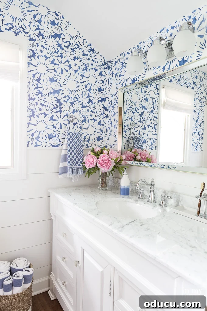 Where should you place a mirror when you want to brighten a dark room? A blue and white bathroom decorated with a mirror, demonstrating a vibrant color palette to brighten a dark room.