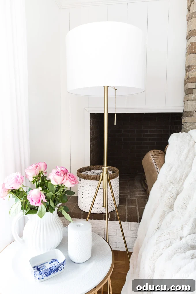 What wattage lightbulb is best to use to brighten a dark room? Elegant brass floor lamp with a white shade illuminating a cozy living room, showcasing effective lighting for enhanced ambiance.