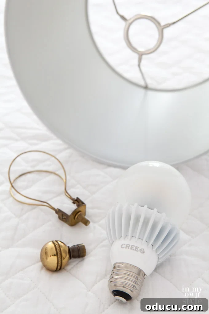 How to brighten a dark room with the right lightbulbs. Do a some experimenting to find just the right color bulb and wattage Close-up of a lamp shade and light bulb, emphasizing the importance of bulb selection for brightening a dark room.
