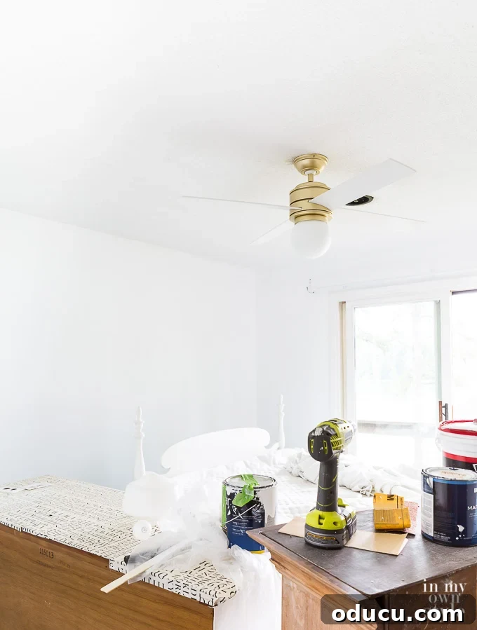 What color should I paint a ceiling to brighten a dark room A bedroom in the process of being painted white, illustrating how ceiling color can significantly brighten a dark room.