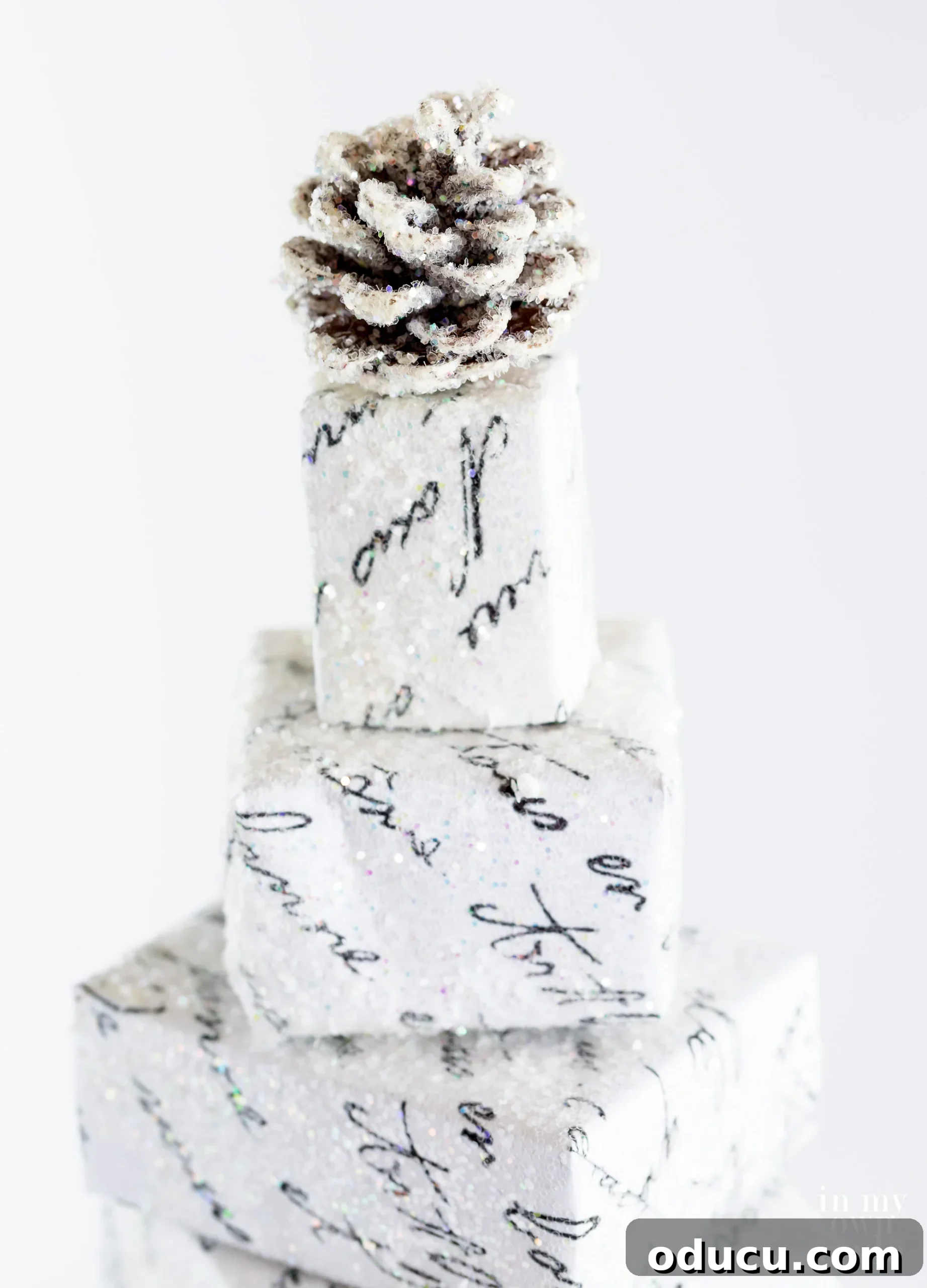 Glittered pinecone as an alternative topper for a stacked box Christmas tree.