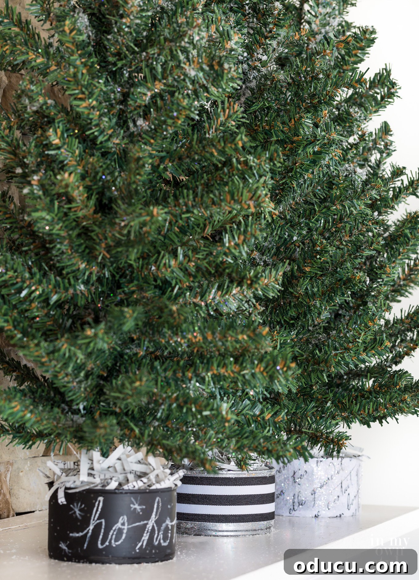 Tiny Tree, Big Style: Base Decor Hacks 7 Three faux pine mini Christmas trees with bases styled in distinct yet complementary ways, offering versatile holiday decor ideas.