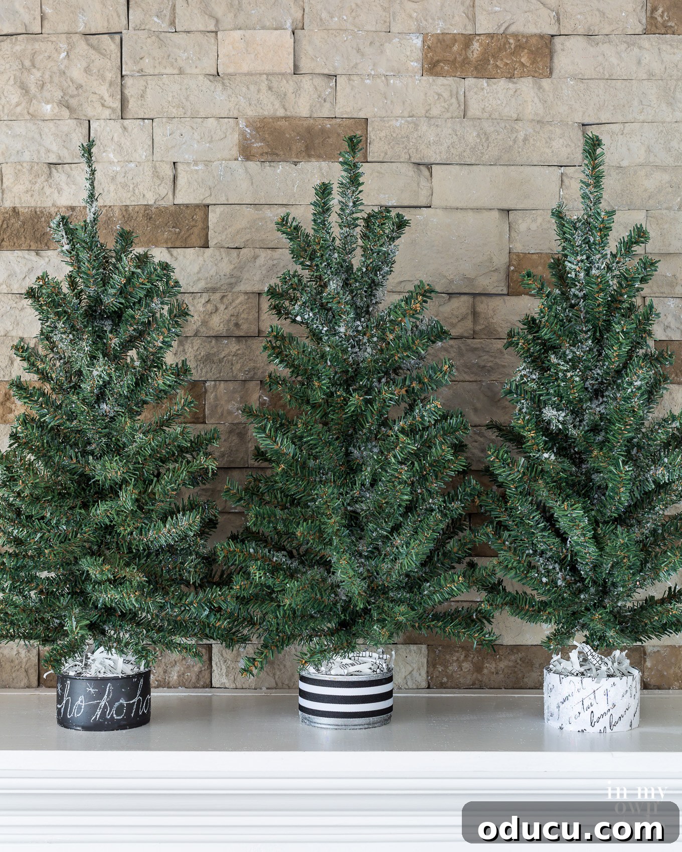 Tiny Tree, Big Style: Base Decor Hacks 8 Three mini Christmas trees featuring stylish black and white bases, ingeniously crafted from repurposed tuna cans, for unique holiday accents.