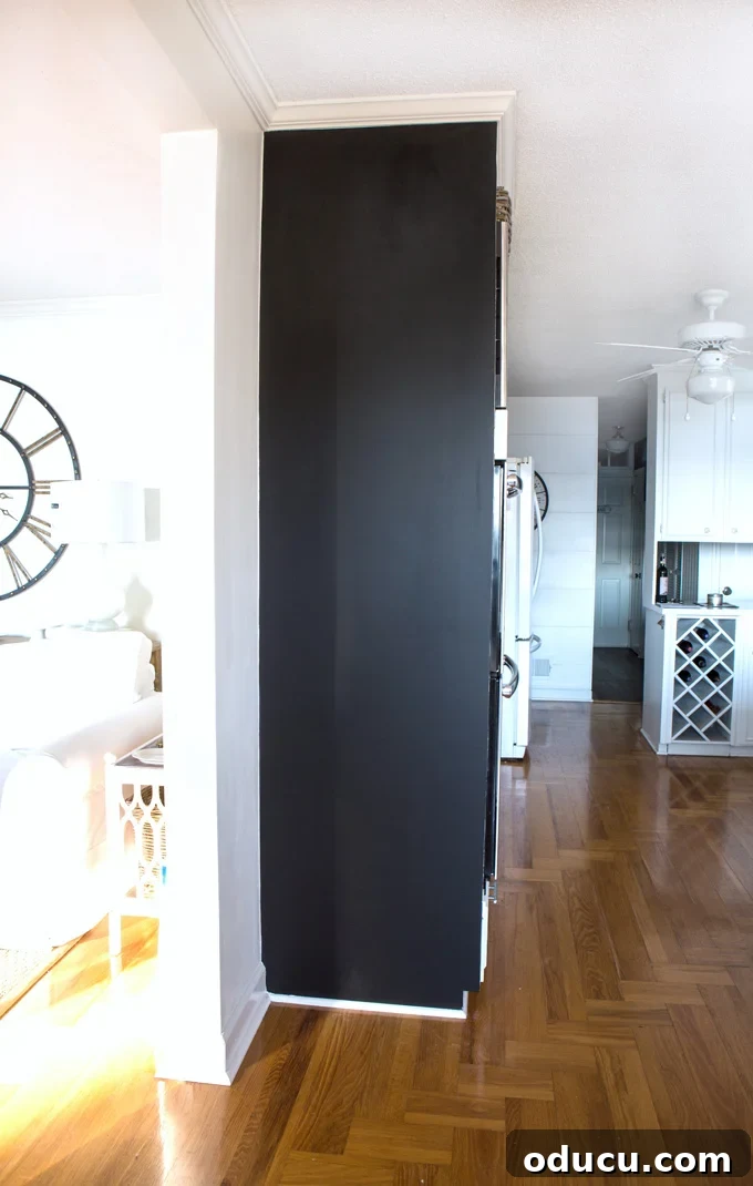Step 1: Painting Your Floor-to-Ceiling Chalkboard Wall Applying black chalkboard paint to a wall to create a floor-to-ceiling chalkboard.
