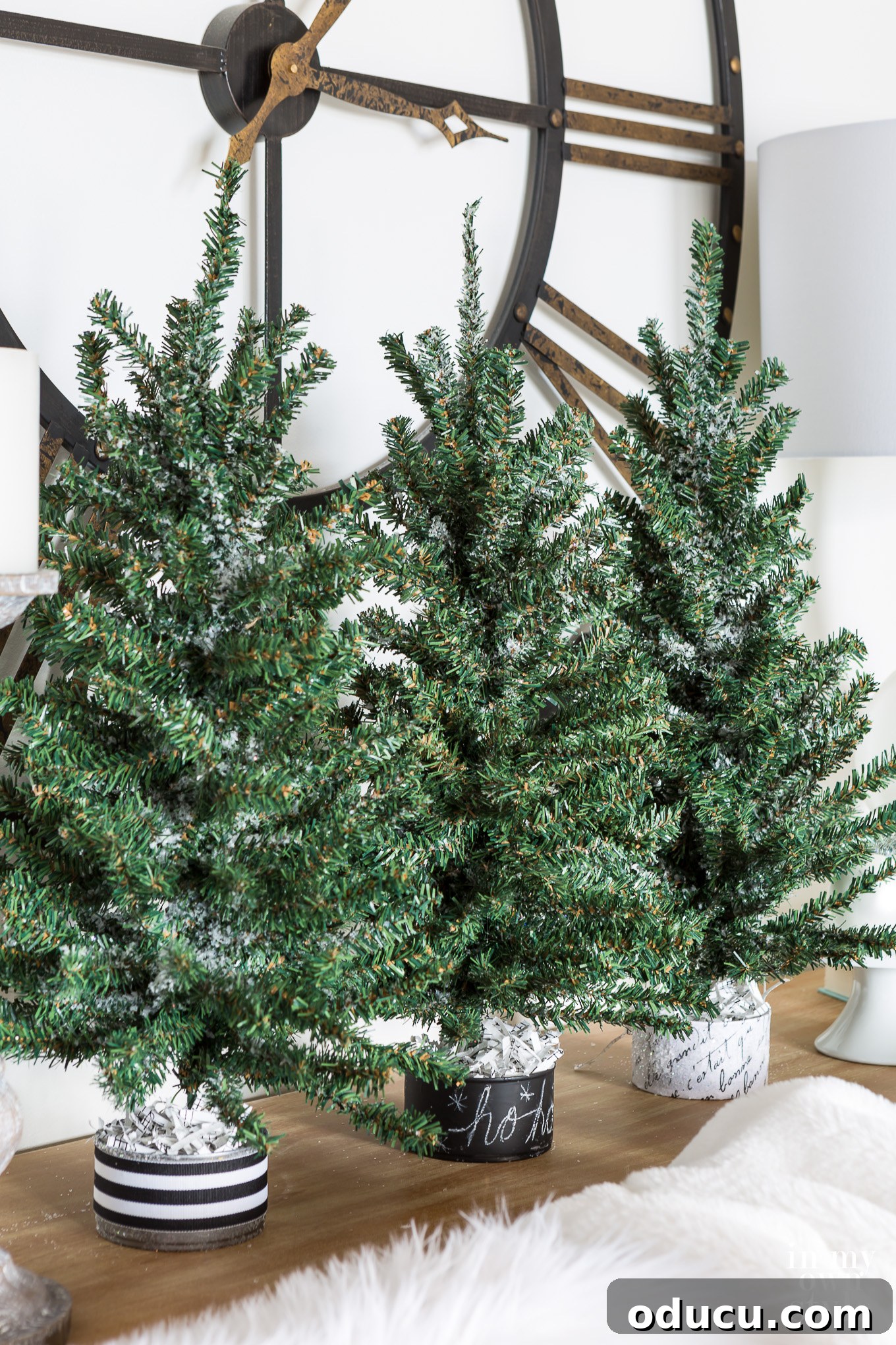 Easy to do Christmas decorating ideas for tables. #Christmasdecor #Jinglebells #Holidaydecorating #naturedecor A trio of mini faux Christmas trees lined up along a sofa table, creating a miniature forest effect