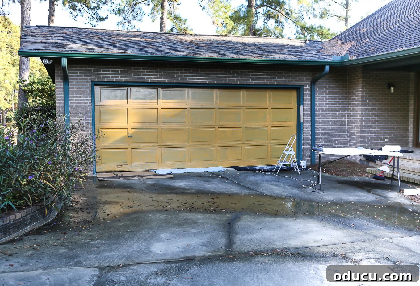 Paint Your Garage Door to Mimic Stained Wood: A DIY Transformation 7 Applying the yellow base coat to a garage door, preparing it to look like wood