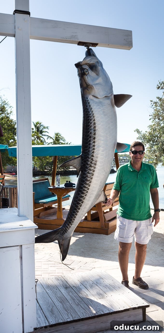 Keys Island Drive Adventure 13 Man posing with a large, fake fish for a photo opportunity at a Florida Keys restaurant