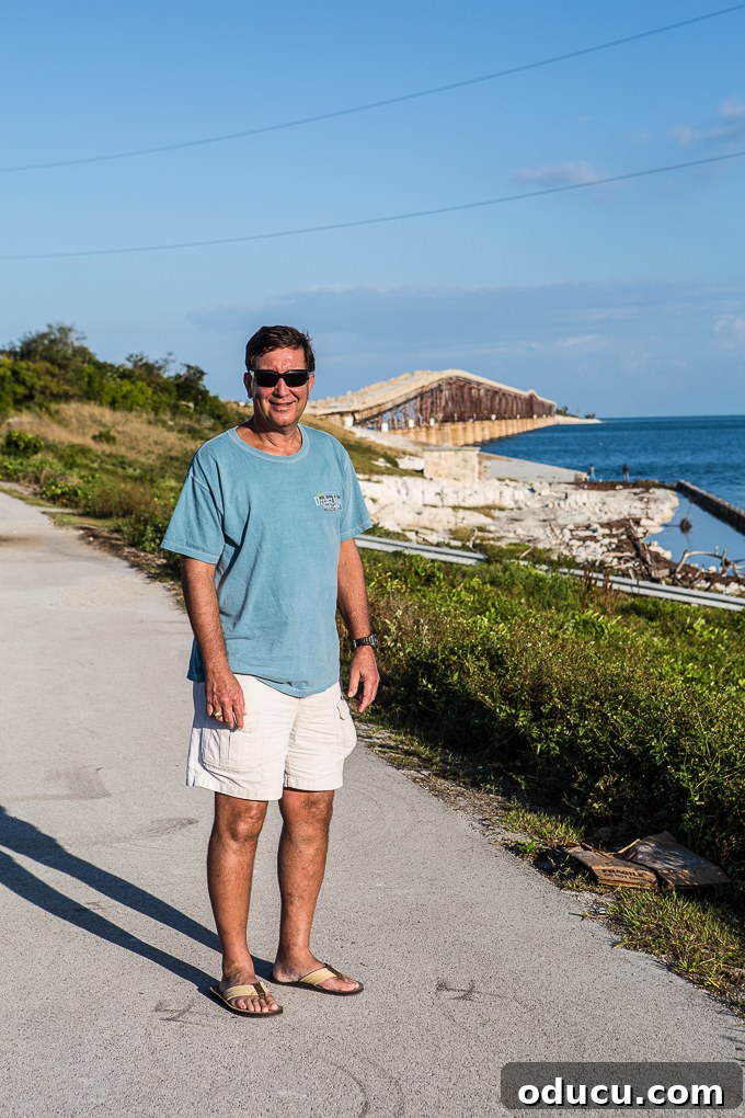 Keys Island Drive Adventure 4 Ed enjoying the view from a Florida Keys bridge, with convertible in the background