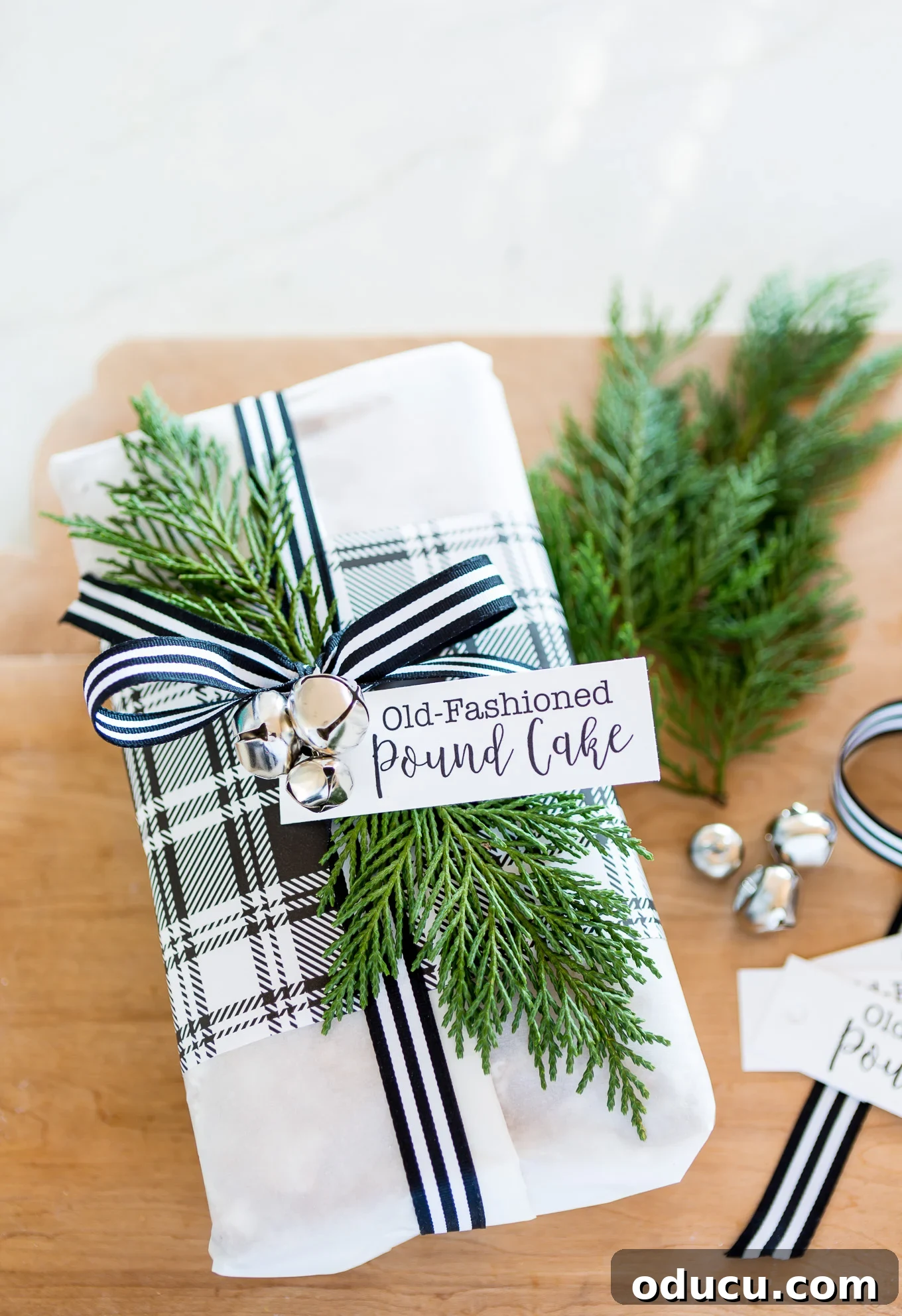 Elevate Your Loaf Cake Gifts with Festive Wrapping 2 Parchment paper wrapped old fashioned lemon pound cake, festively tied with ribbon and jingle bells for a holiday gift.