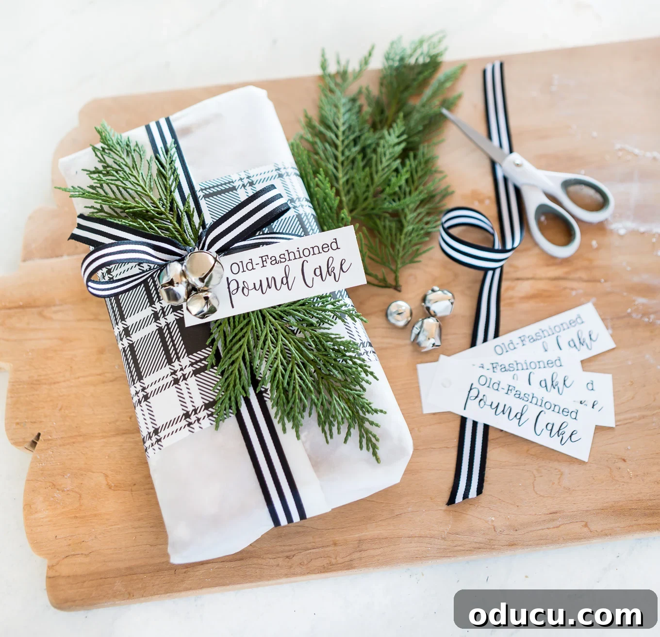 Elevate Your Loaf Cake Gifts with Festive Wrapping 7 Beautifully gift-wrapped lemon pound cake with elegant ribbon, jingle bells, and a personalized tag.