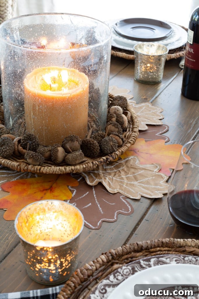 Glass hurricane on a wicker plate charger. Pumpkin color candle and acorns make a nice centerpiece.