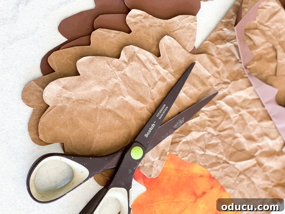 cutting brown paper into fall leaves