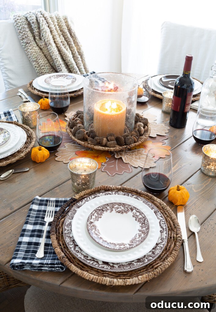 Looking down at a round wood dining table set for Thanksgiving.