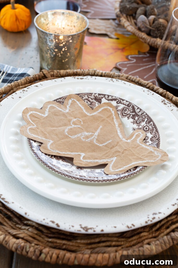 paper oak leaf place card on top of a dinner plate on a table