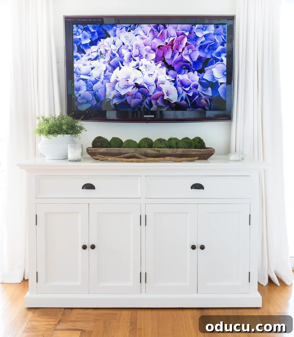 White farmhouse furniture below a wall mounted TV