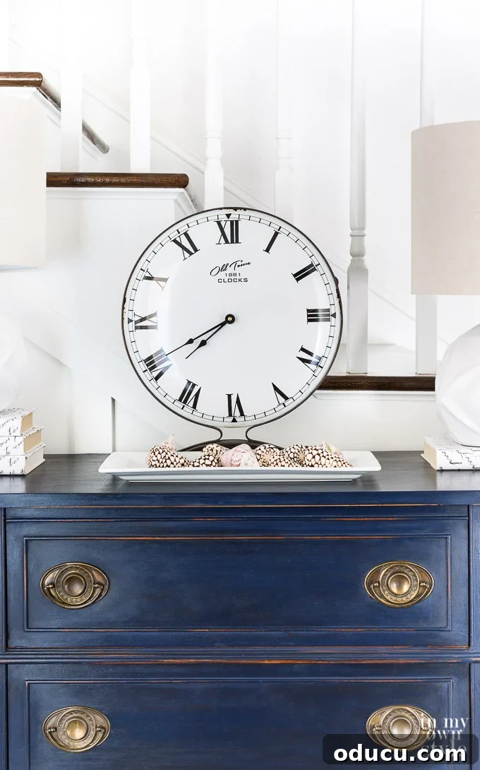 Optimize your daily routine to live your best life this year. Elegant DC Blue Chalk painted sideboard with a classic clock on top, symbolizing reclaimed time and mindful living.