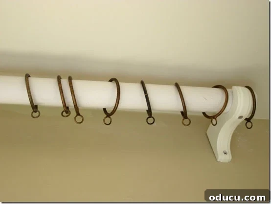How to Put Curtain Rods and Rings How to put curtain rods and rings, showing a close-up of drapery hooks inserted into fabric.