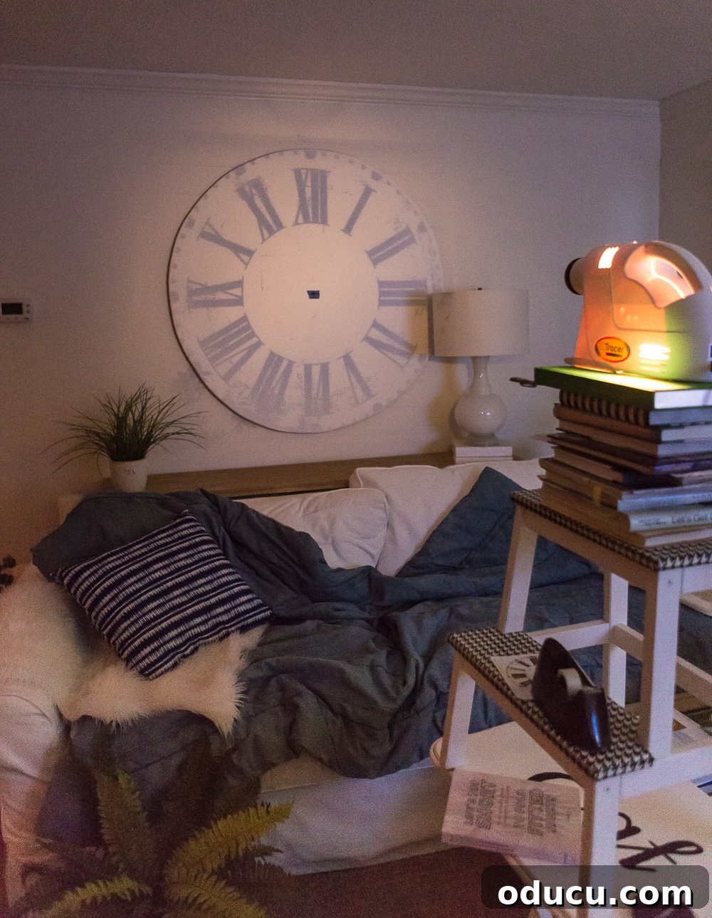 DIY Giant Farmhouse Wall Clock 10 A small art projector displaying a clock face onto a wall, demonstrating how to enlarge designs for an oversized wall clock or a wall mural project.