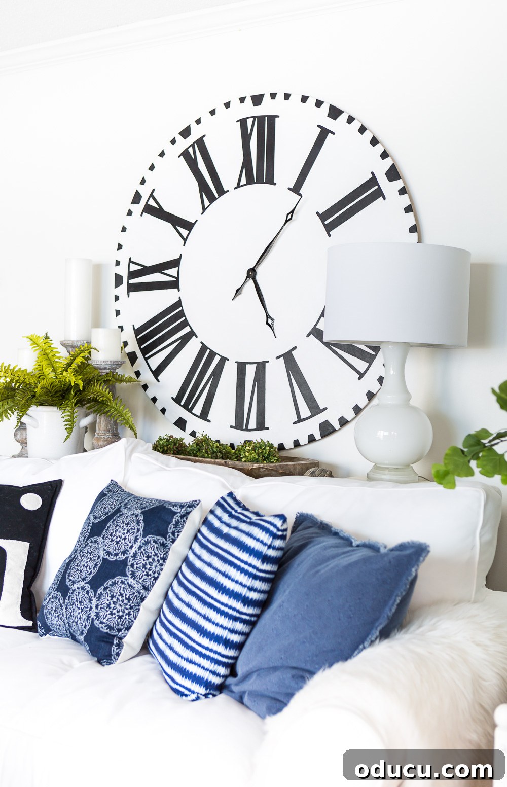 DIY Giant Farmhouse Wall Clock 17 A stunning Fixer Upper Inspired DIY Oversized Wall Clock proudly displayed on a wall, ready to become a focal point in any room.