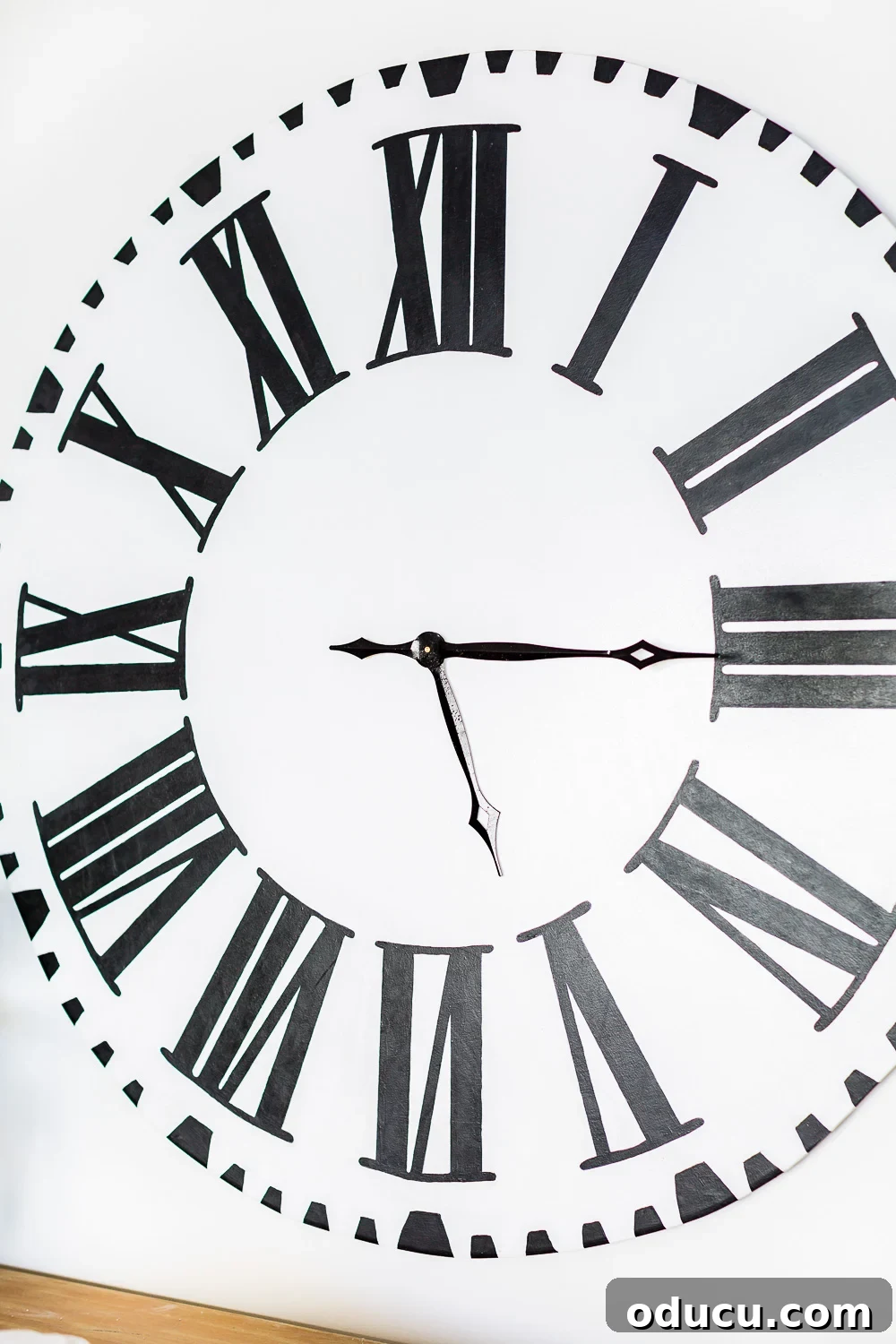 DIY Giant Farmhouse Wall Clock 19 A detailed close-up of a DIY Fixer Upper Inspired Wall Clock, highlighting the hand-painted Roman numerals and the rustic texture of the clock face.