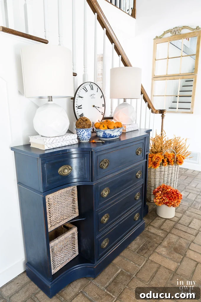 Really small budget decorating ideas using paint. Blue sideboard in foyer all painted and decked out for fall.