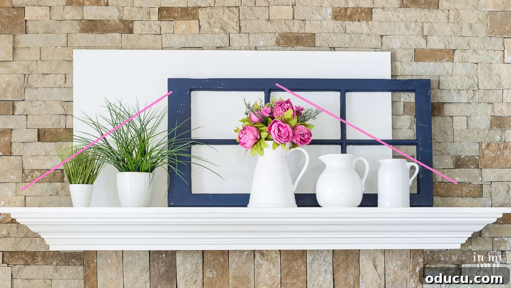 Mantel decorating tips for homeowners. Practical tips for homeowners on decorating a mantel, featuring an asymmetrical arrangement with fewer items on the left side for a modern, dynamic look.