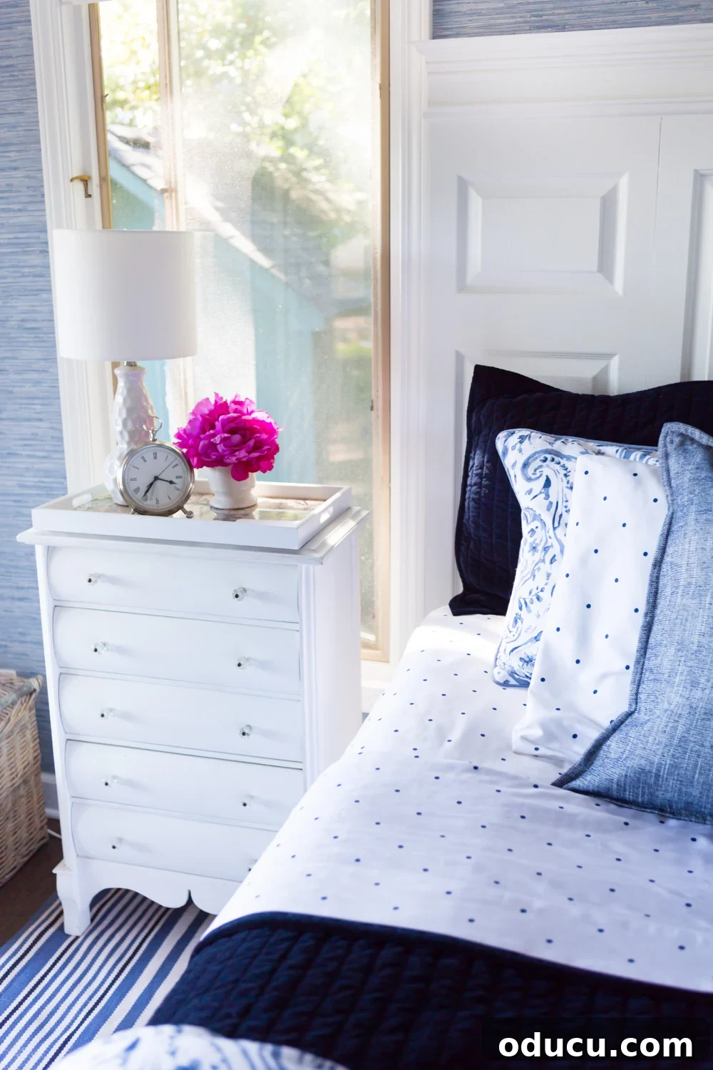 Embracing the SLOW Method for Mindful Decorating 10 Elegant bedroom interior featuring white painted furniture, a blue and white decorated bed, and thoughtful decor