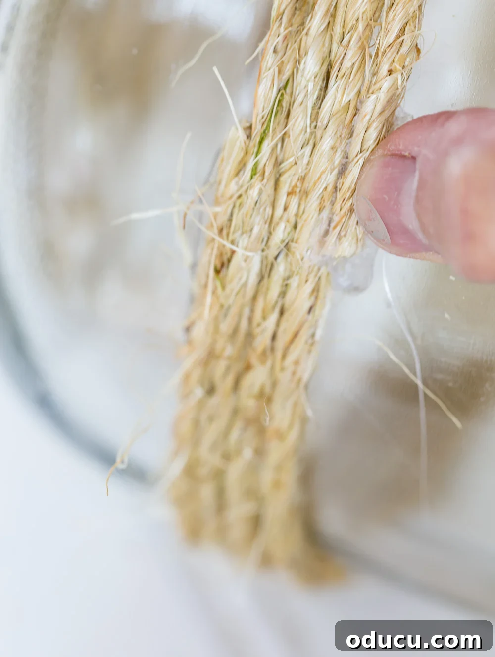 Craft a Stunning Oversized Glass Candle Lantern 8 A large glass jar with twine meticulously wrapped around its base, showcasing the progression of the DIY candle lantern.