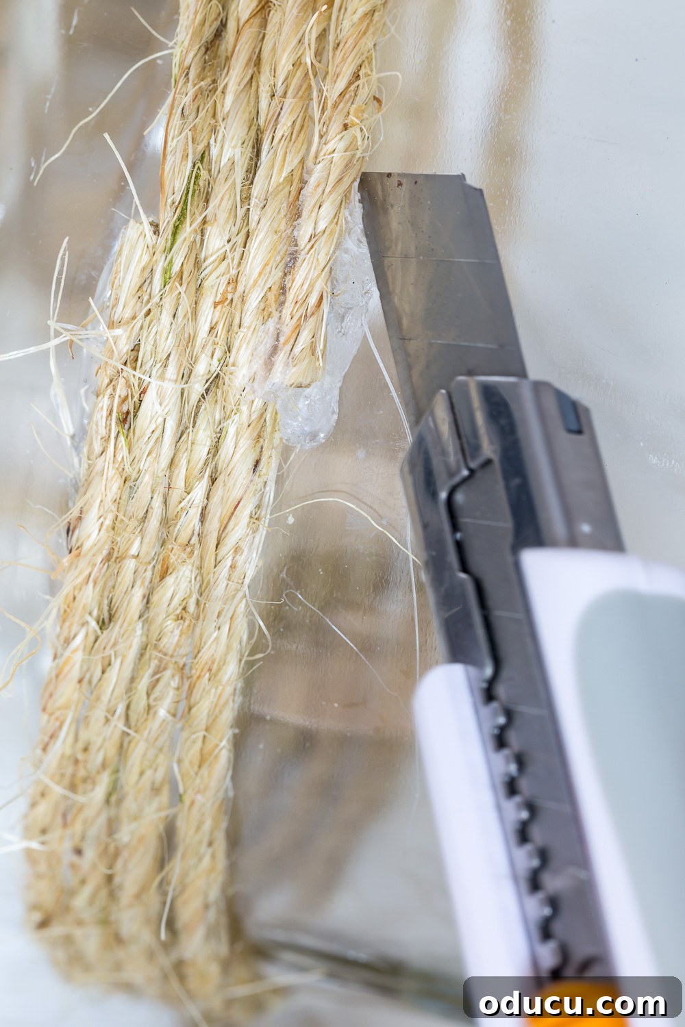 Craft a Stunning Oversized Glass Candle Lantern 9 Technique for removing excess hot glue from a DIY candle lantern made by repurposing a large glass food jar, ensuring a clean finish.