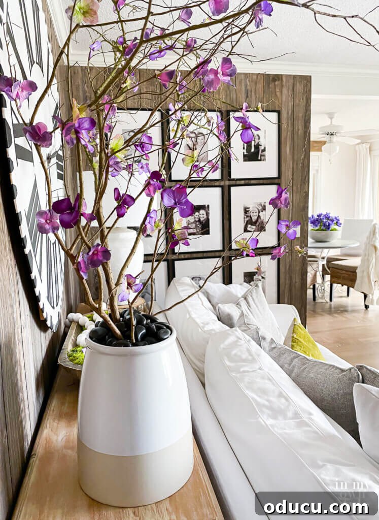 One Wall, Big Impact 11 Faux blooming branches in a large planter behind a sofa, creating an accent corner