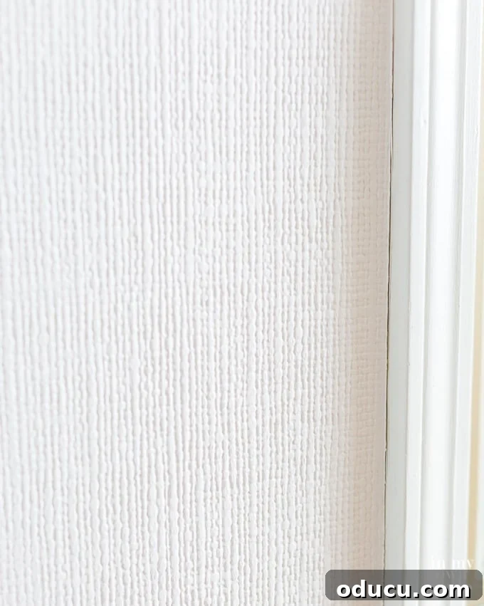 One Wall, Big Impact 13 Close up photo showing white textured wallpaper on a wall in a kitchen dining area