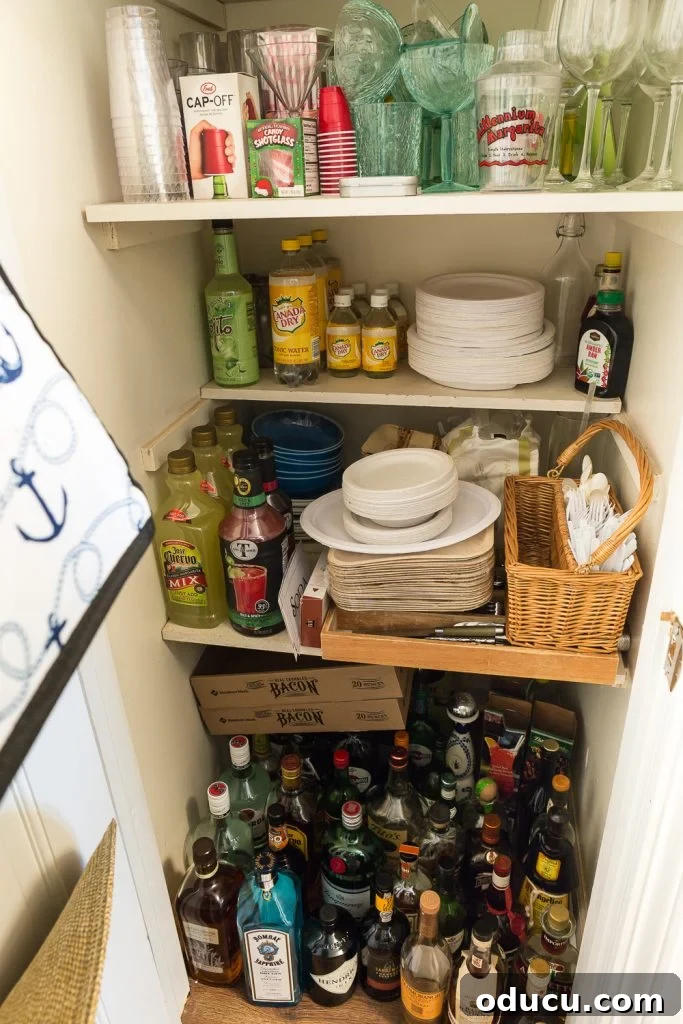My Party Style Sanctuary 7 An organized party closet featuring shelves filled with entertaining supplies like liquor bottles, glassware, and baskets, emphasizing easy hosting.