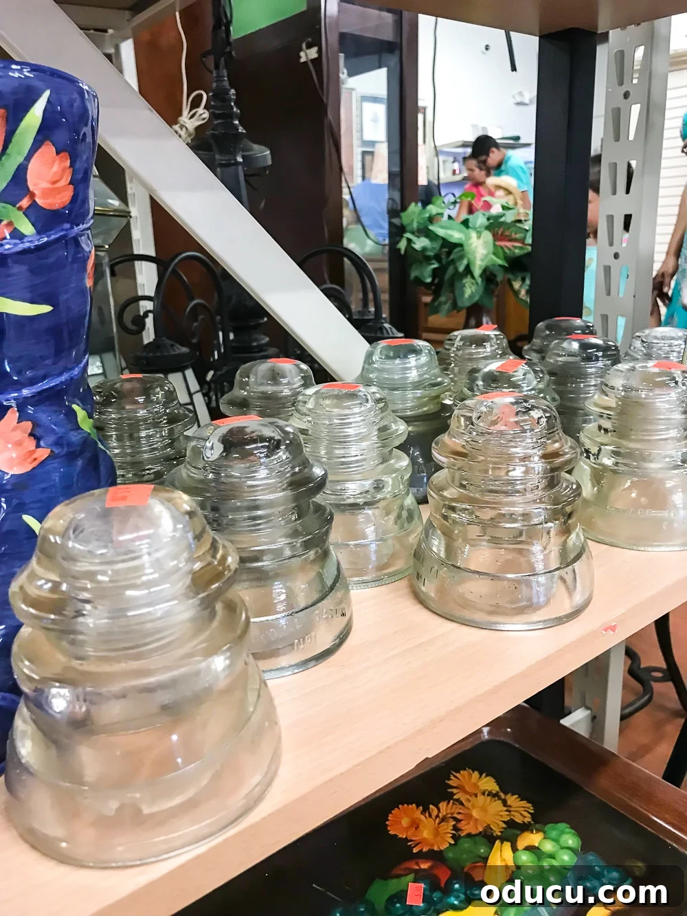 Echoes in Every Element 3 Vintage glass insulators on a thrift store shelf, waiting to be discovered as meaningful decor pieces to make a house a home.