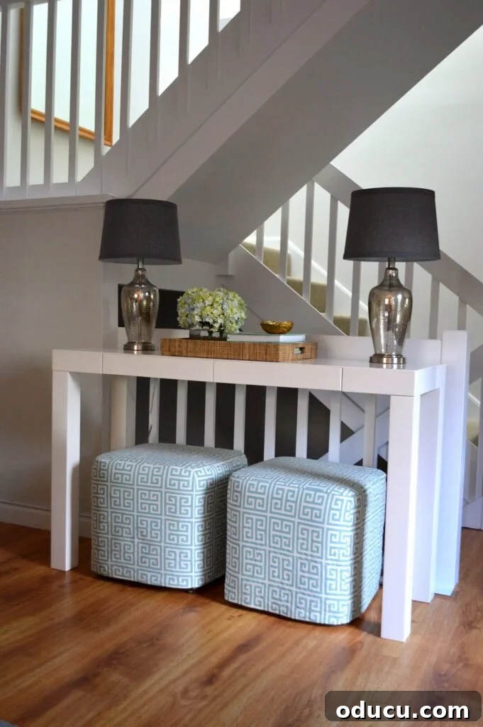Ottomans: From Footrest to Focal Point 14 A stylish entryway or foyer featuring clever decorating with ottomans tucked neatly under a console table, optimizing space.