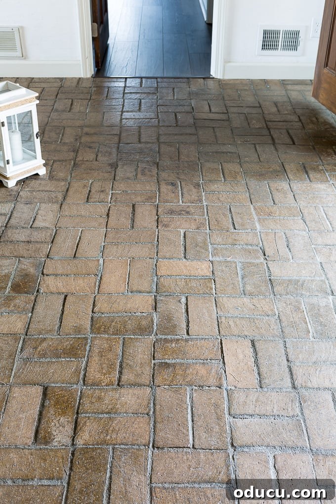My $14 Whitewashed Brick Floor Makeover 3 Close-up of a brown brick floor before whitewashing