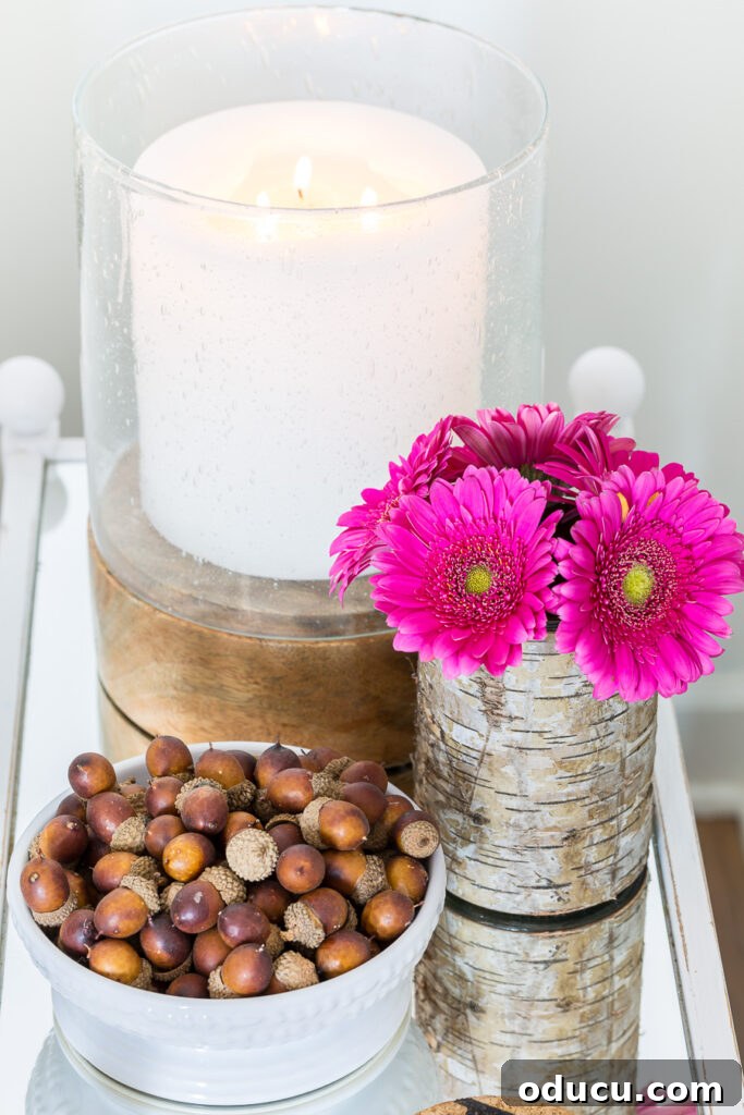 Autumn Nesting: Decor Ideas for Fall 11 Deep pink fall flowers and acorns on a mirror side table, adding a pop of color