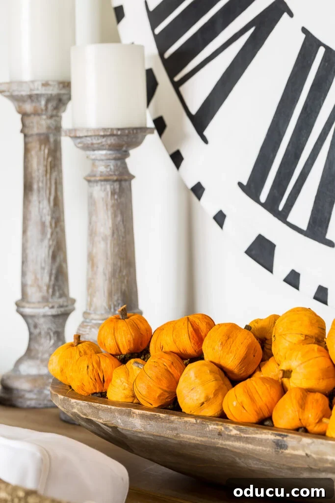Autumn Nesting: Decor Ideas for Fall 14 Long wood dough bowl filled with paper mini pumpkins behind a sofa
