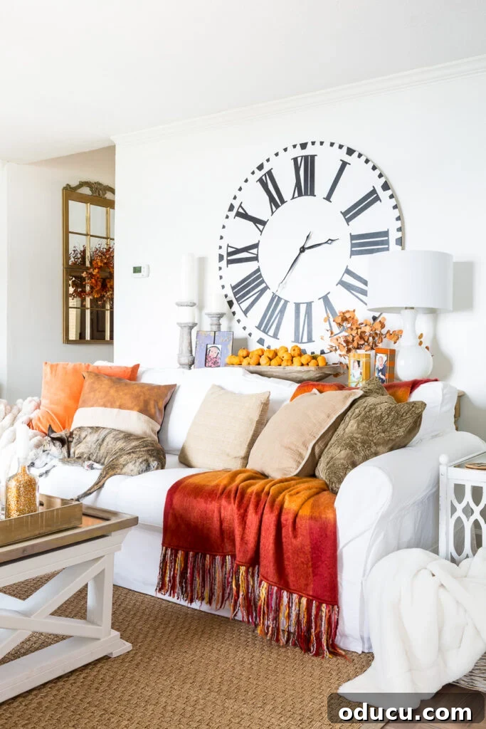 Autumn Nesting: Decor Ideas for Fall 5 Living room decorated for fall with orange and brown accents, a navy sofa, and cozy throws