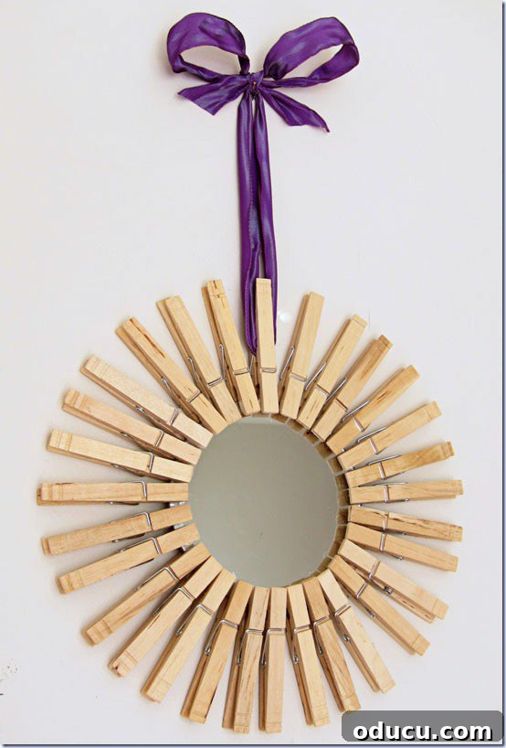 How to hang a DIY Starburst mirror on a wall with purple ribbon. DIY Starburst mirror hung on wall with purple ribbon