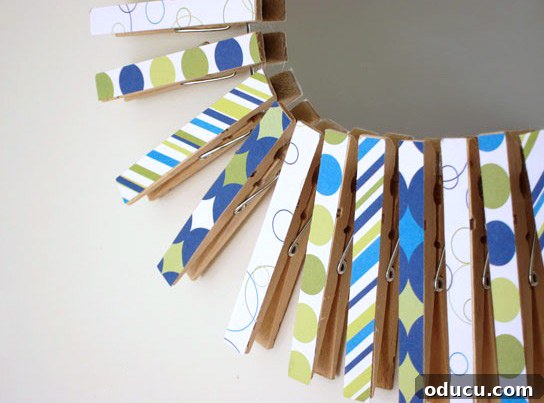 How to make a colorful sunburst mirror DIY Scrapbook paper covered clothespins creating a frame on a round mirror