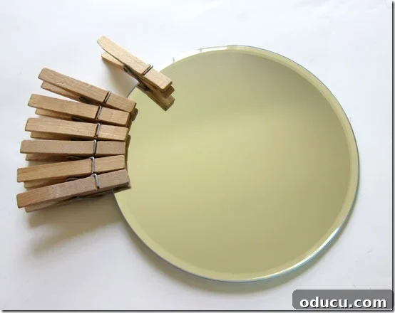 How-to-attach-clothespins-to a round mirror to make a DIY sunburst mirror. How-to-attach-clothespins-to a round mirror