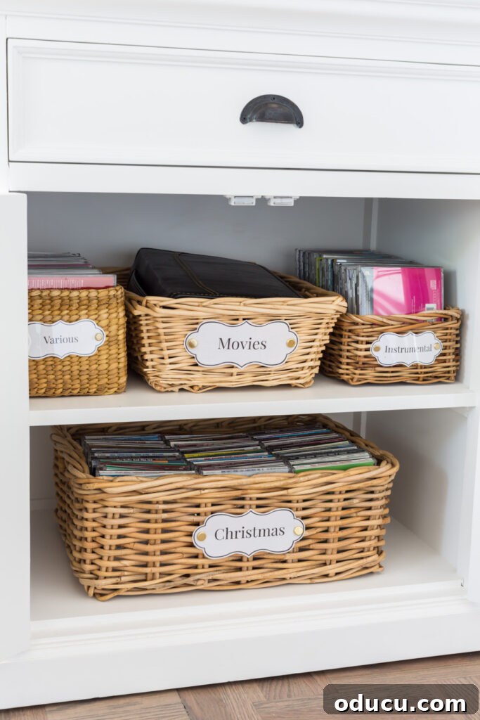Chic Storage Without the Splurge 6 Storage baskets with laminated DIY labels arranged on the shelves inside a storage cabinet.
