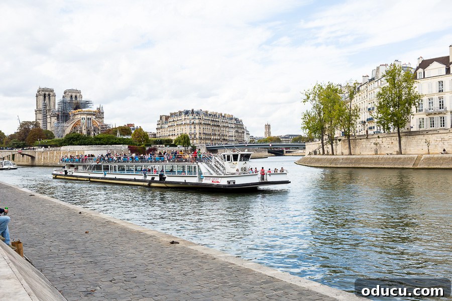 A bustling tourist boat gliding gracefully along the serene waters of the Seine in Paris, filled with sightseers.